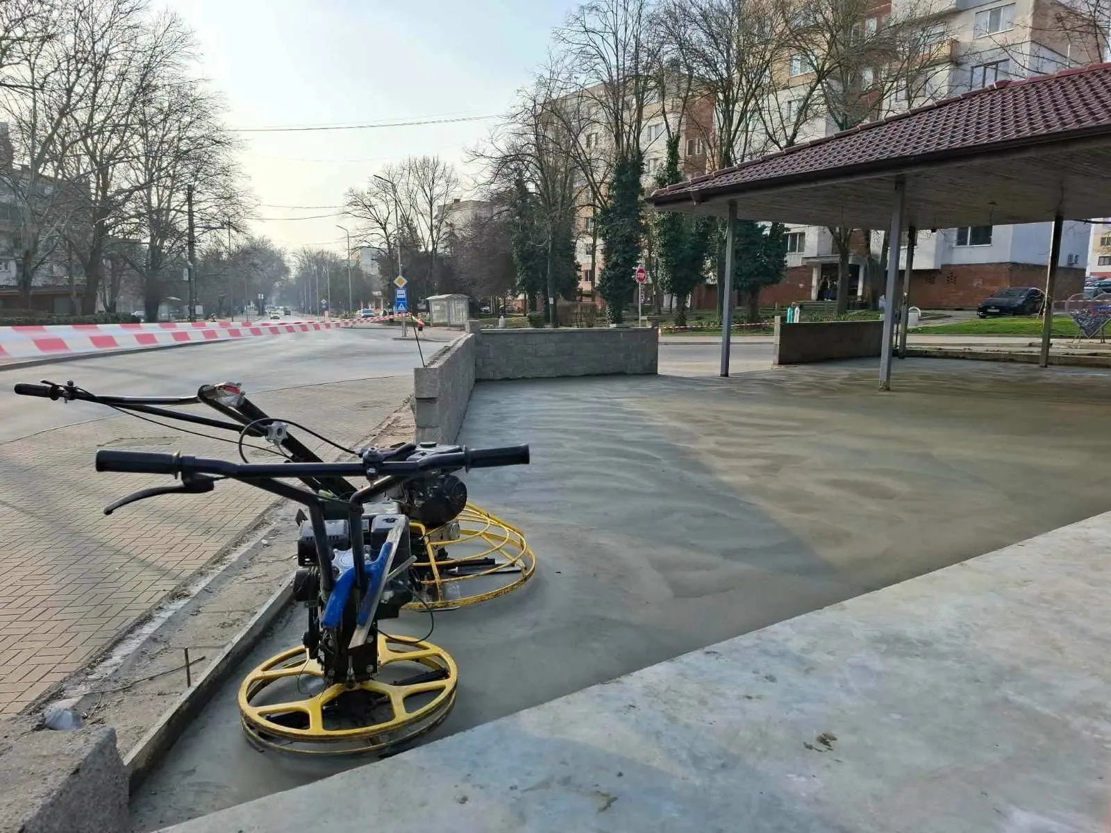 Машини за пердашене върху прясно излята настилка край улица